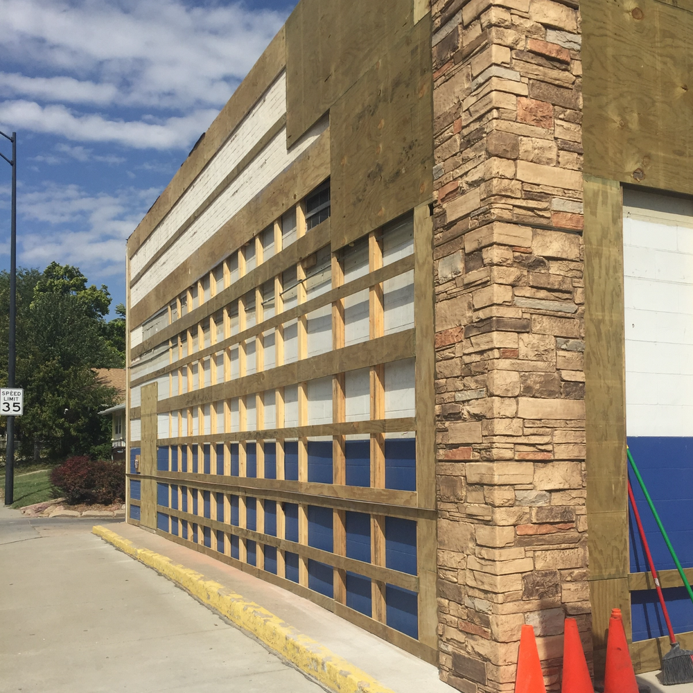 Building exterior in progress with desert oasis color ledgestone stone facade on corner and plywood studwall