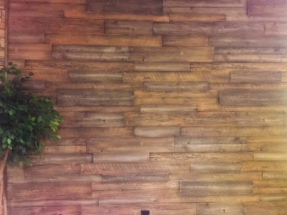 Installed URESTONE Reclaimed Wood accent wall staggered planks, rustic brown grain, interior feature.