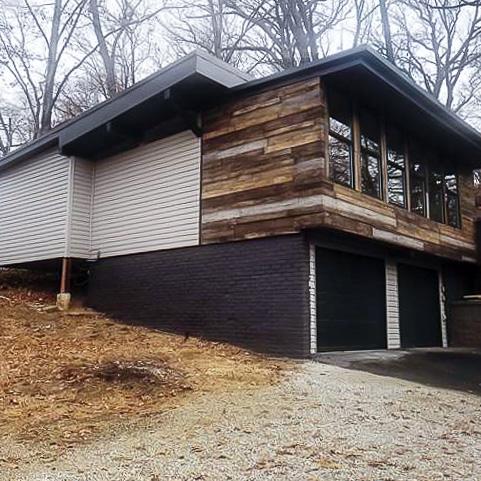 Home remodel using URESTONE reclaimed faux wood panels above brick garage, modern rustic exterior cladding.