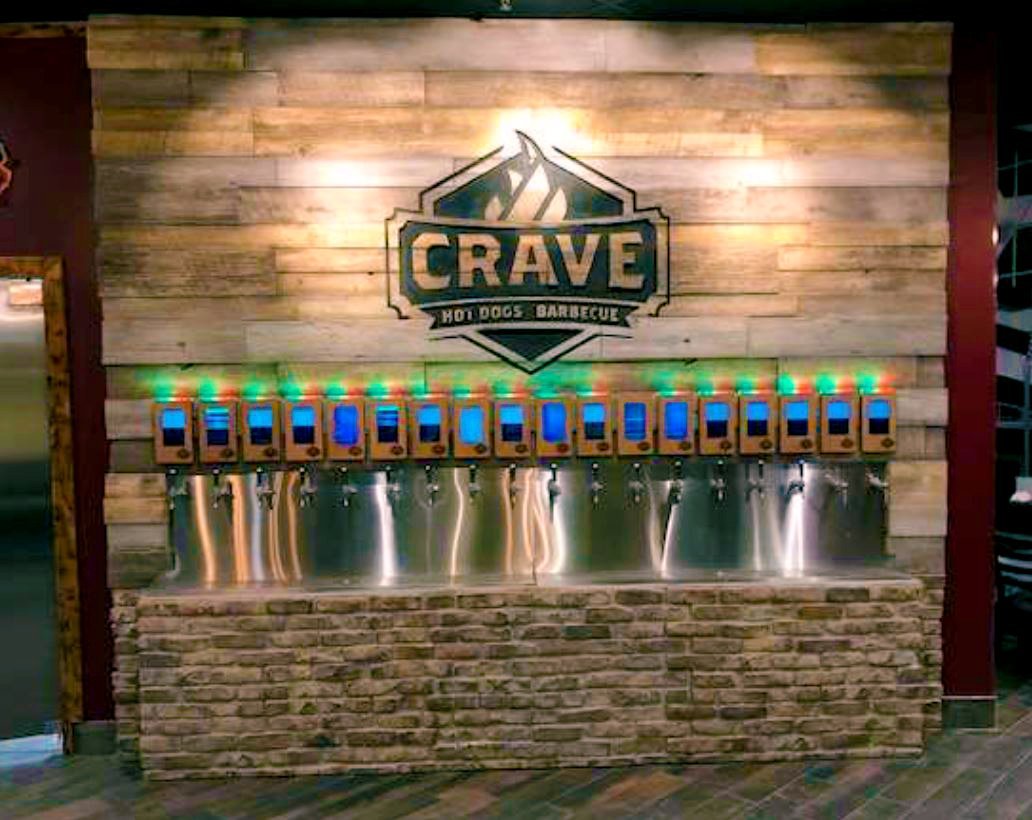 Restaurant tap wall with URESTONE reclaimed faux wood panels and faux stone base, warm rustic feature wall.