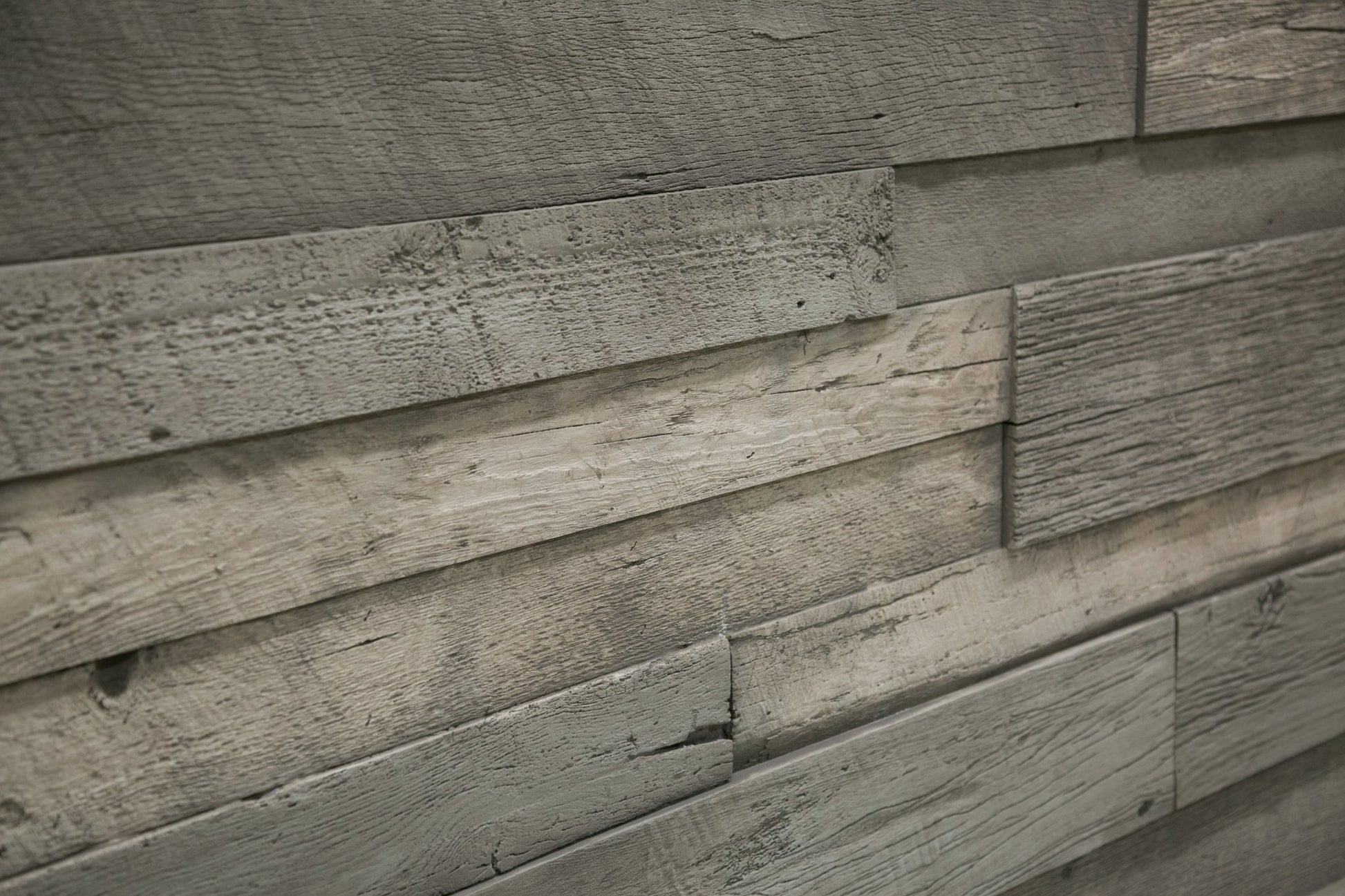 Installed URESTONE reclaimed faux wood panels driftwood gray planks, weathered grain, layered 3D relief.