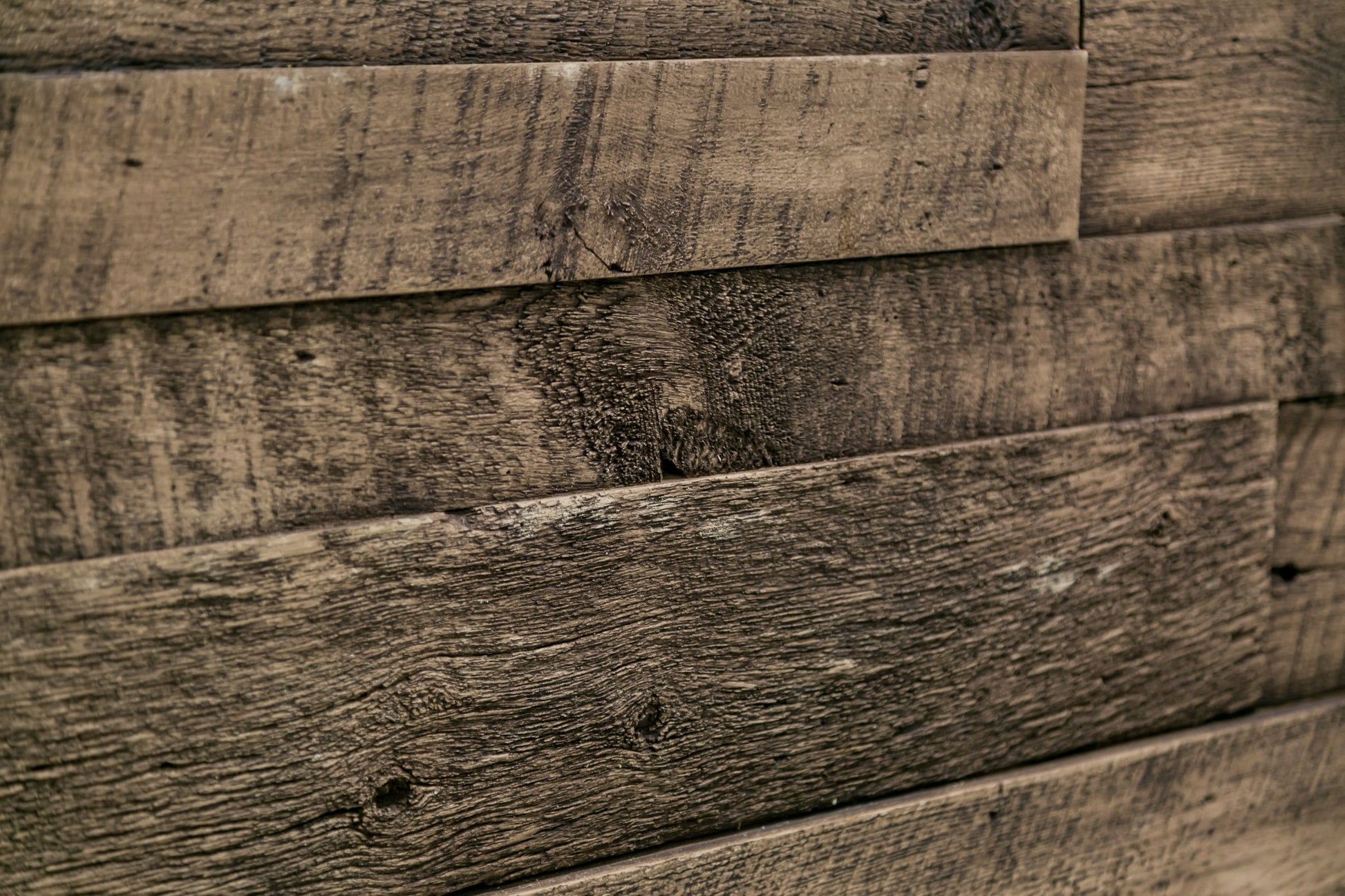 Close-up of Reclaimed Wood faux wood wall panels brown planks with deep grain, knots and saw marks, layered 3D texture.