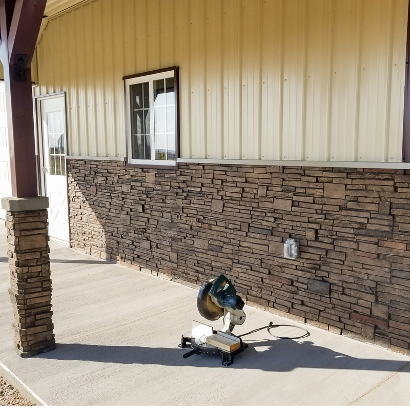 Brown stacked stone realistic wall panels with matching stone column wraps on metal building with cream colored siding