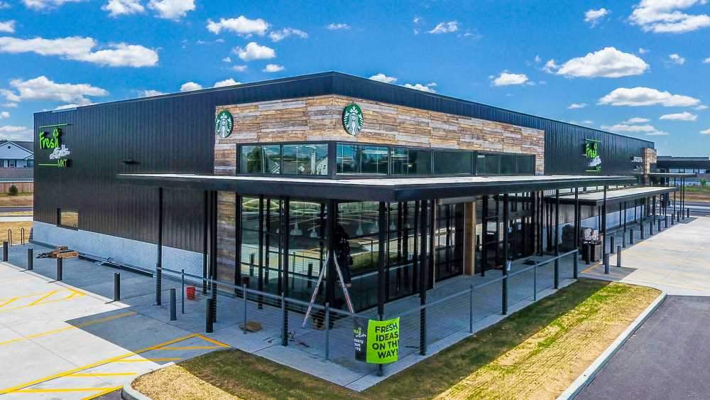Modern Starbucks building wrapped with URESTONE reclaimed faux wood panels horizontal bands, durable exterior cladding.